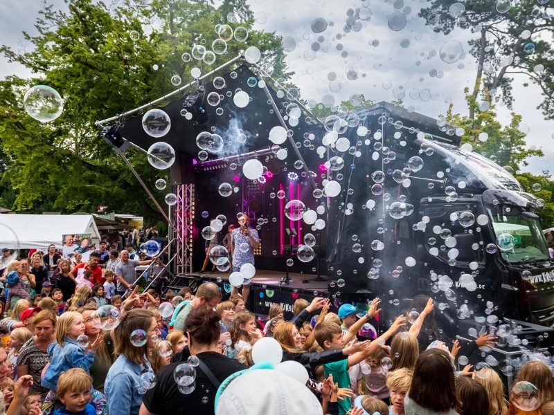 Die mobile Eventbühne Road Stage mit spektakulärer Lichtinstallation bei einem Open-Air-Konzert mit Seifenblasenmaschine